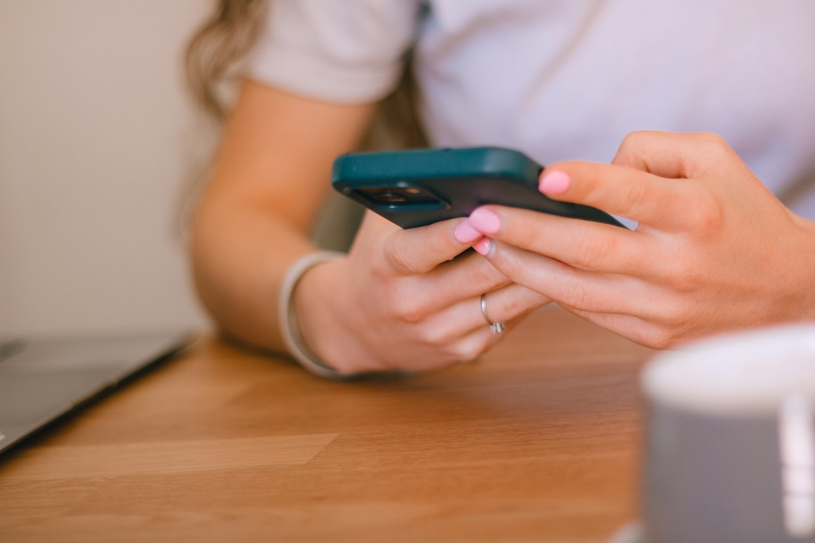 Hands with an engagement ring typing a message on a phone